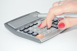 woman finger pressing calculator button 