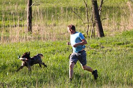 man running with a dog